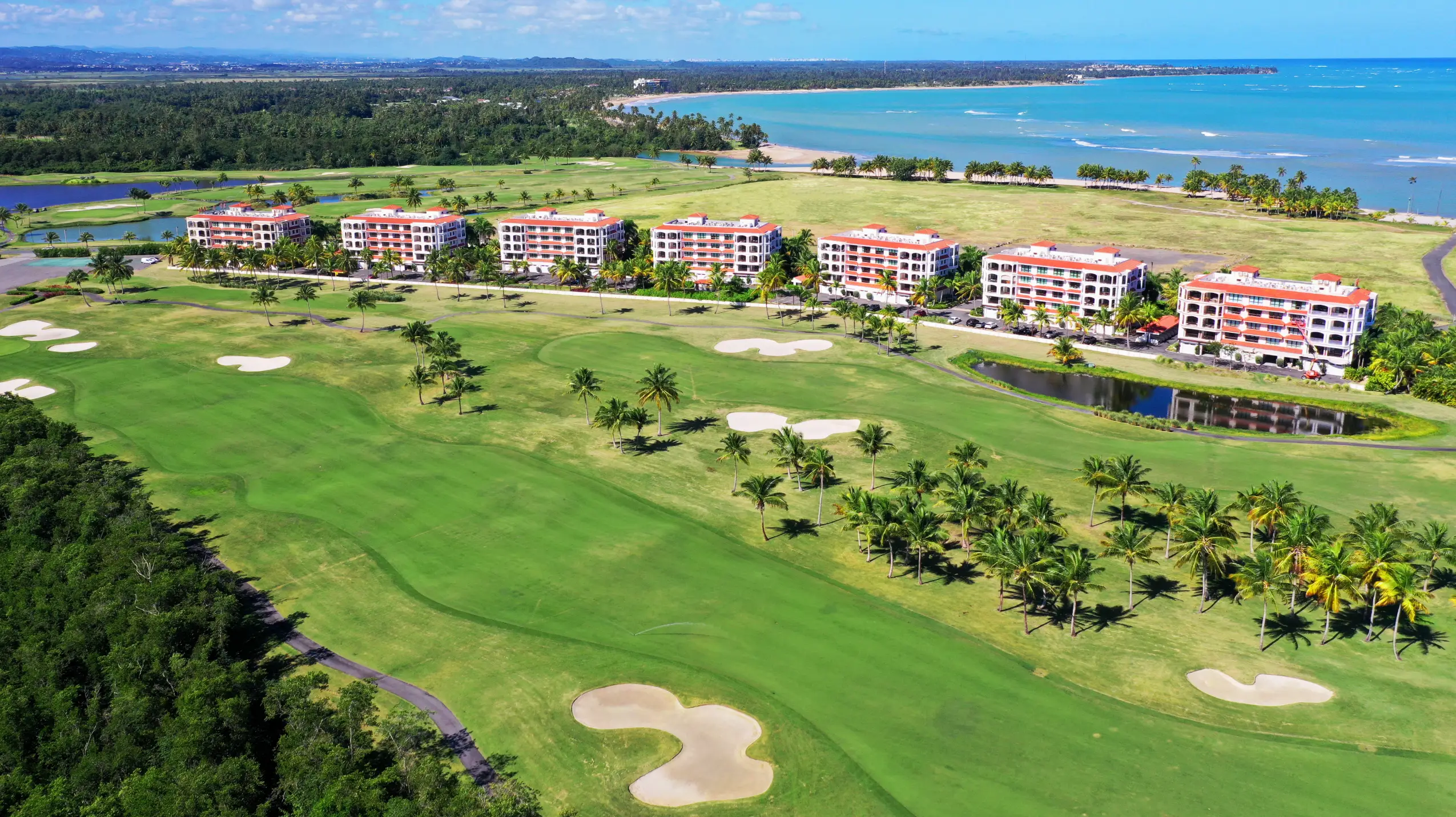 Aerial perspective of the Celeste Country Club Residences resort complex, highlighting The Club Celeste's distinctive architecture, manicured greens, and proximity to the beach.