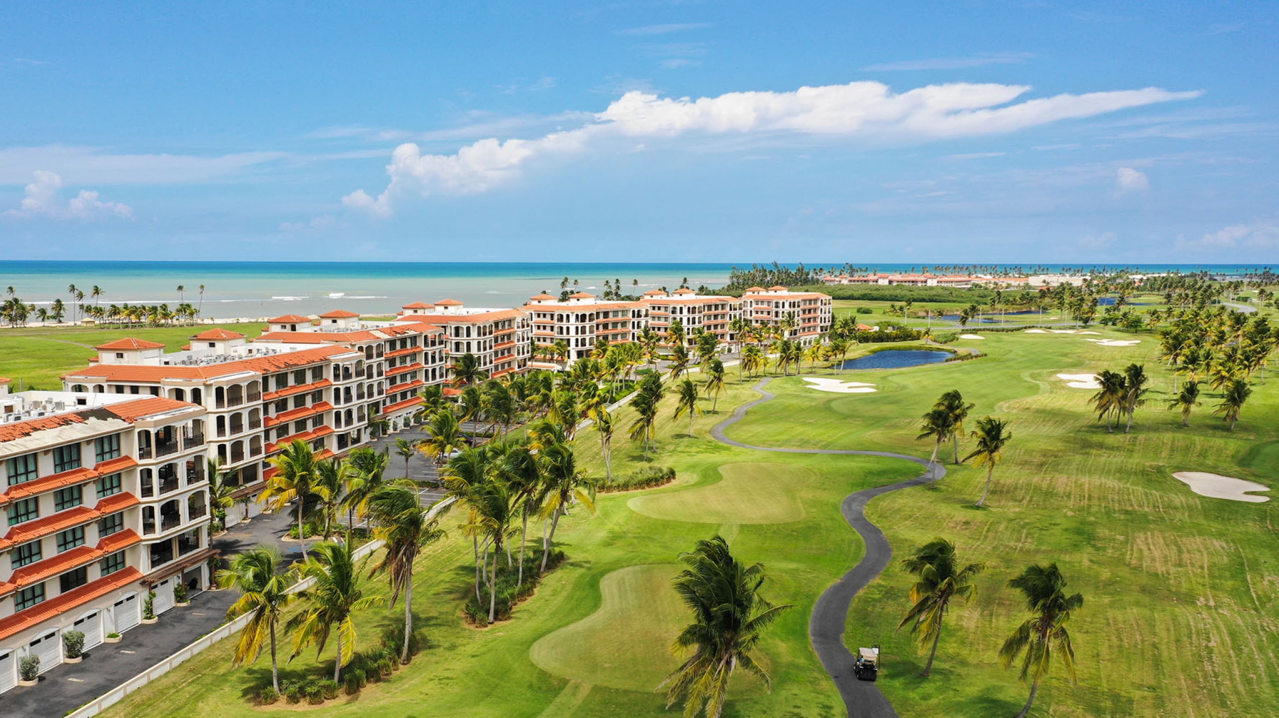 Aerial perspective of the Celeste Country Club Residences resort complex, highlighting The Club Celeste's distinctive architecture, manicured greens, and proximity to the beach.