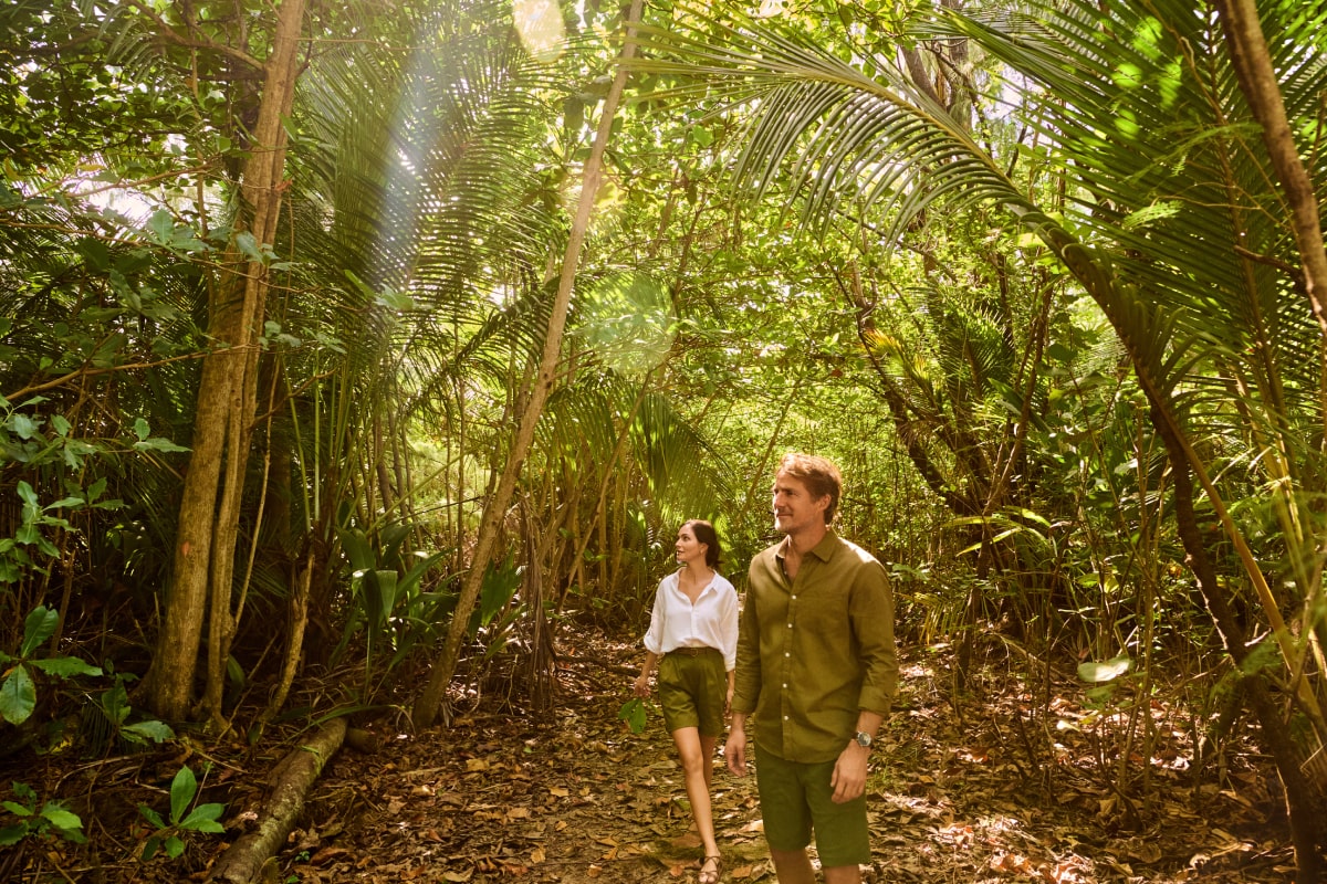 Within the lush greenery of Grand Reserve, a couple explores the rich biodiversity of Puerto Rico, enjoying a tranquil walk through the resort's private forest trails
