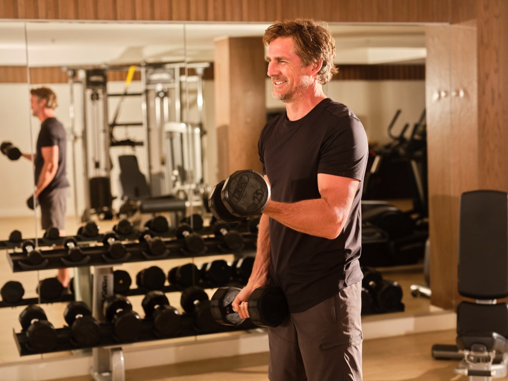 Focused individual working out at Grand Reserve's well-equipped gym, reflecting the resort's commitment to holistic luxury living